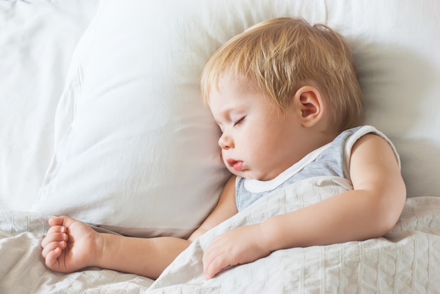 Süßes Little Boy, das auf Bett schläft