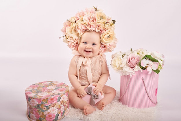 Süßes lustiges Babyporträt mit Blumen