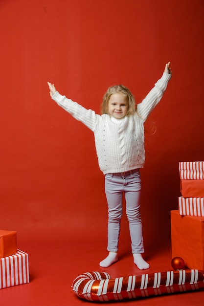 Foto süßes mädchen bereitet sich im hintergrund mit geschenken auf das neue jahr vor