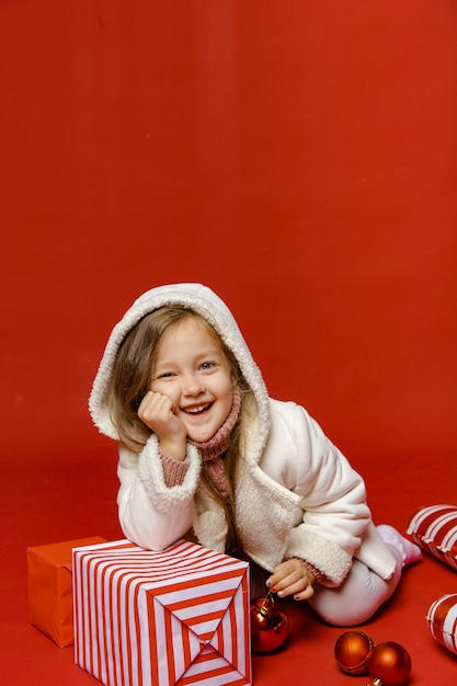 Foto süßes mädchen bereitet sich im hintergrund mit geschenken auf das neue jahr vor