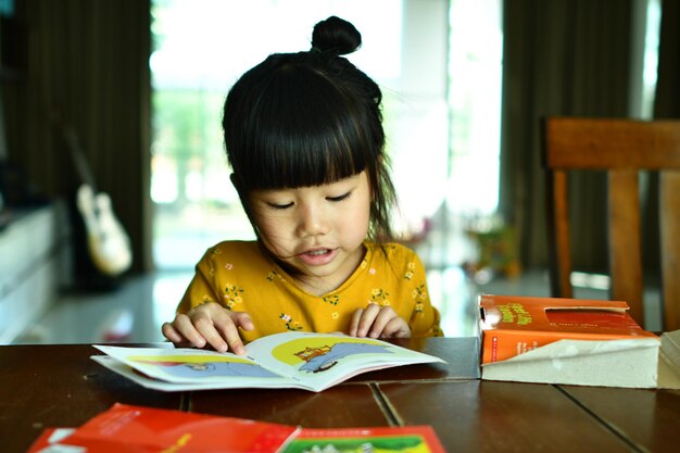 Süßes Mädchen liest zu Hause ein Buch