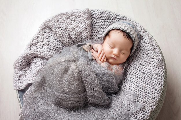 Süßes neugeborenes Baby schläft in einem Korb.