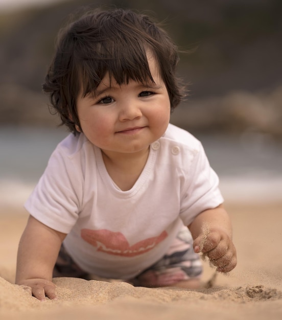 Süßes spanisches Baby an einem Sandstrand