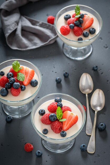 Süßes und vanilliges Panna Cotta, serviert im Glas mit Beeren