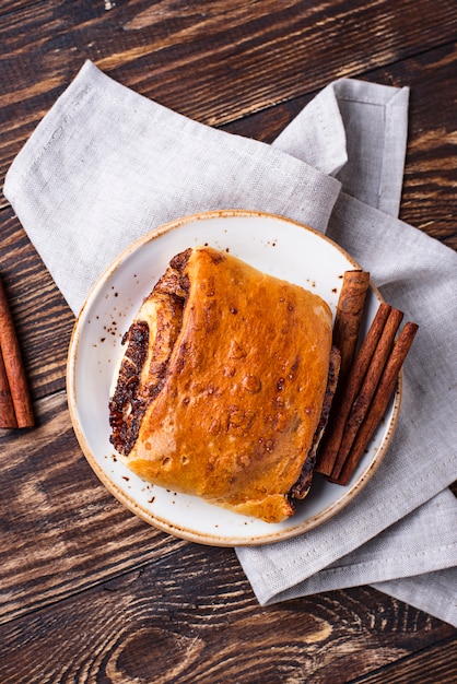 Süßes Zimtbrötchen auf Holztisch