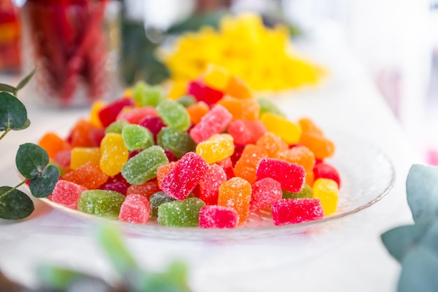Foto süßigkeiten aller farben auf einem teller auf einem tisch bei einer kindergeburtstagsfeier