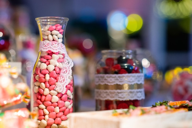 Süßigkeiten in einem Glas über einem Tisch mit Bokeh-Hintergrund