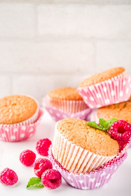 Süßspeise, hausgemachtes gebackenes Muffin mit Himbeermarmelade, serviert mit Tee, frischen Himbeeren und Minze