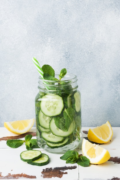 Süßwasser im Glas mit Zitrone, Gurke und Minze auf Holztisch. Platz kopieren