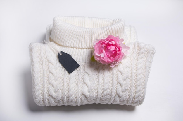 Suéter quente branco bem dobrado na prateleira Roupas novas com etiqueta