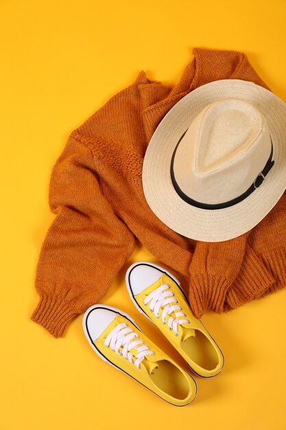 Suéter, zapatillas y gorro sobre fondo amarillo.