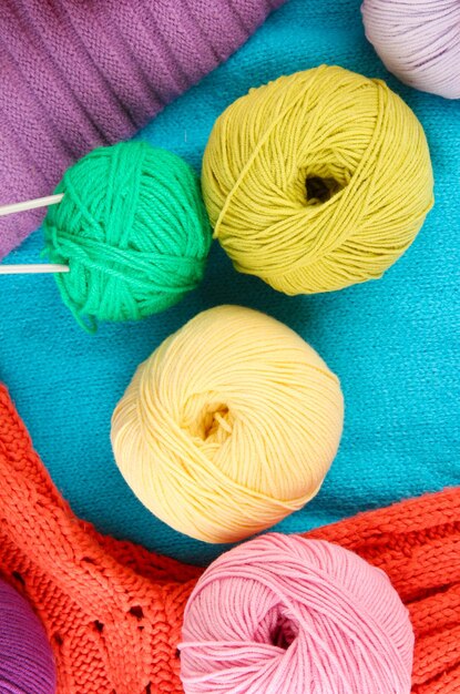 Suéteres de lana de colores y ovillos de lana closeup