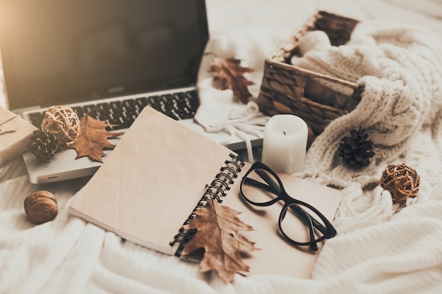Suéteres y taza de té con notebook, laptop y ropa de tejer