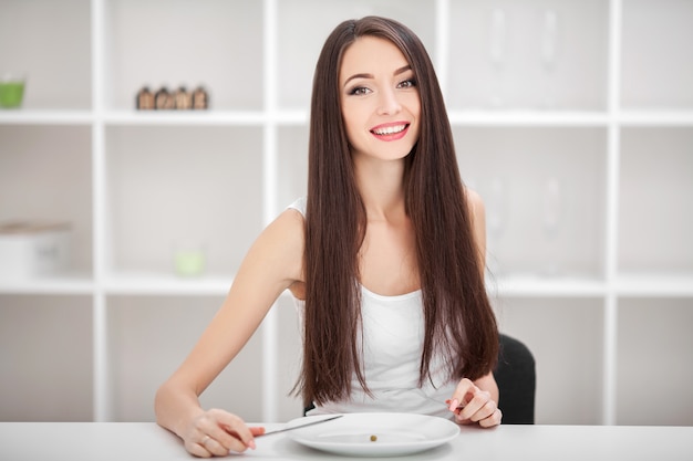 Sufriendo de anorexia. Imagen de niña tratando de poner un guisante en el tenedor