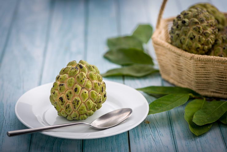 Foto sugar apple em um prato branco com uma colher de aço inoxidável pronta para ser comida