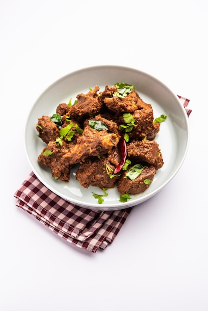 Sukha-Hammel- oder Hühnerfleisch, trocken, würzig, Murgh oder Ziegenfleisch, serviert in einem Teller oder einer Schüssel