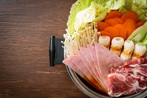 Sukiyaki o shabu sopa negra de olla caliente con carne cruda y vegetales - estilo de comida japonesa