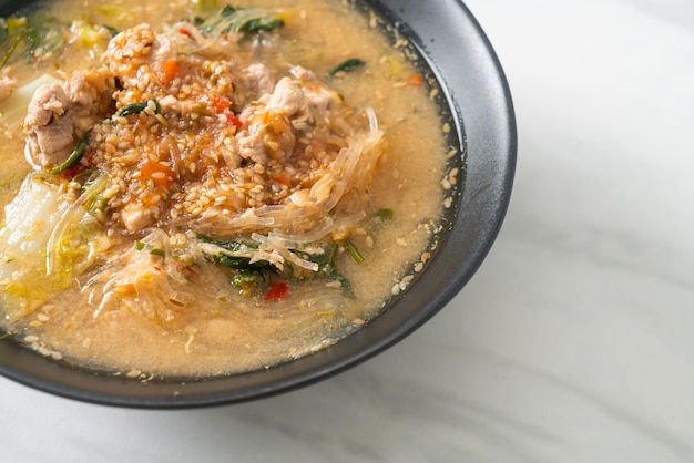Sukiyaki-Suppe mit Schweinefleisch nach thailändischer Art oder gekochte Fadennudeln mit Schweinefleisch und Gemüse in Sukiyaki-Suppe nach asiatischer Art