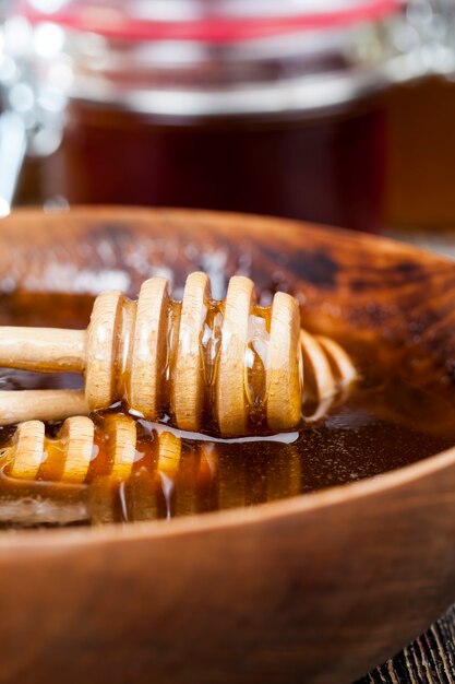 Sumergido en miel elaborada especialmente a partir de cuchara gruesa casera de madera, miel de abeja dulce y cuchara de madera que le permite transferir y verter la miel sin que gotee ni se esparza.