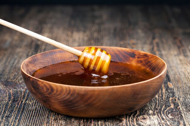 Sumergido en miel elaborada especialmente a partir de cuchara gruesa casera de madera, miel de abeja dulce y cuchara de madera que le permite transferir y verter la miel sin que gotee ni se esparza.