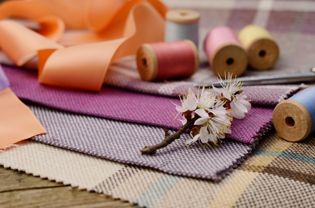 Suministros de costura, agujas, tijeras en el colorido textil de yute