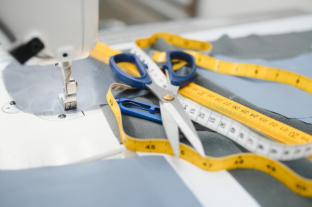 Foto suministros de costura en la mesa al lado de la máquina de coser