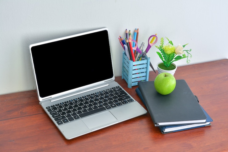 Foto suministros de oficina, laptop con notebook y apple en mesa de madera