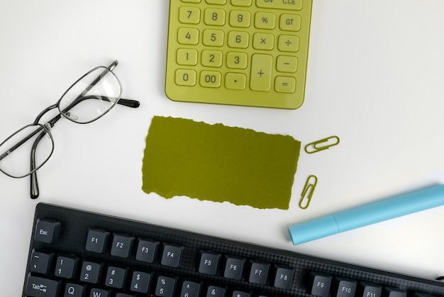 Suministros de oficina sobre escritorio con teclado y vasos y taza de café para trabajar de forma remota