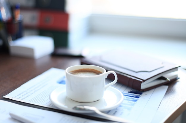 Suministros de oficina y taza de café en la mesa