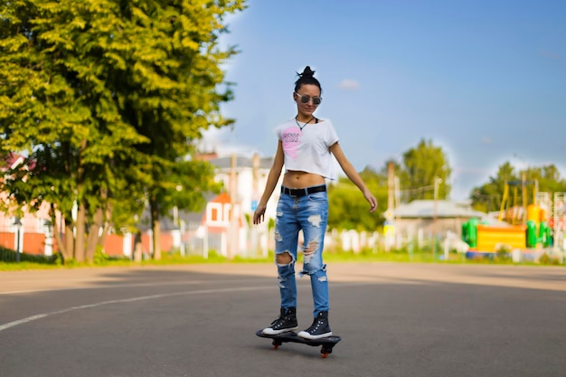 Summer la chica en el parque montando una patineta