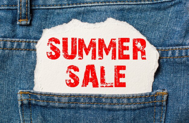 Summer Sale auf weißem Papier in der Tasche der blauen Jeans