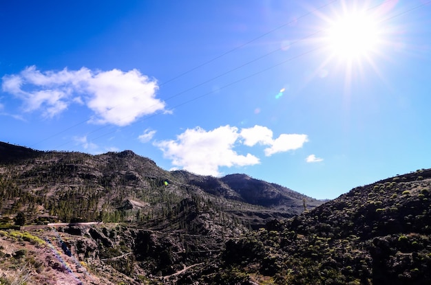 Sun Star en un cielo azul sobre una silueta de montaña en Gran Canaria España