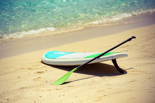 Sup Board na praia de areia nas Maldivas com a escrita I love Gulhi