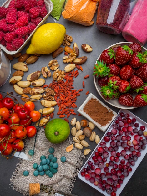 Foto súper alimento para retrasar el proceso de envejecimiento concepto que incluye suplementos de frutas en polvo nueces píldoras bayas alto contenido de antioxidantes antocianinas fibra dietética vitaminas