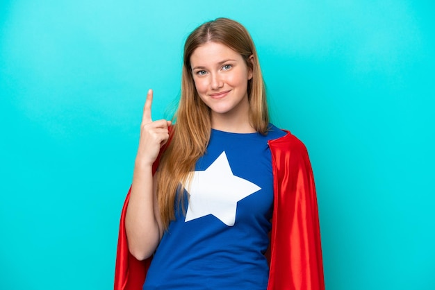 Super Hero kaukasische Frau isoliert auf blauem Hintergrund zeigt mit dem Zeigefinger eine großartige Idee