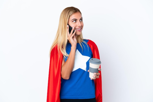 Super Hero kaukasische Frau isoliert Hintergrund mit Kaffee zum Mitnehmen und ein Handy