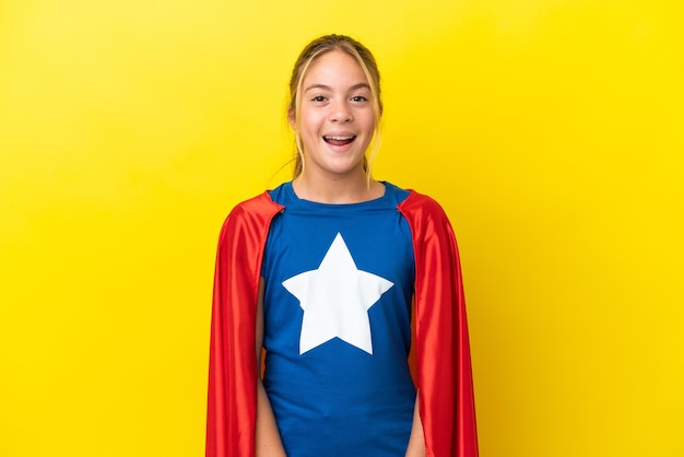 Super Hero kleines Mädchen auf gelbem Hintergrund mit Überraschungsgesichtsausdruck isoliert