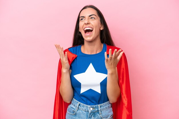 Super Hero mujer caucásica aislada sobre fondo rosa con expresión facial sorpresa