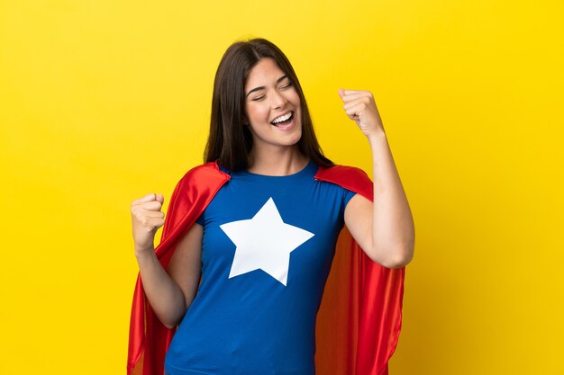 Foto super-heroína brasileira isolada em fundo amarelo comemorando vitória