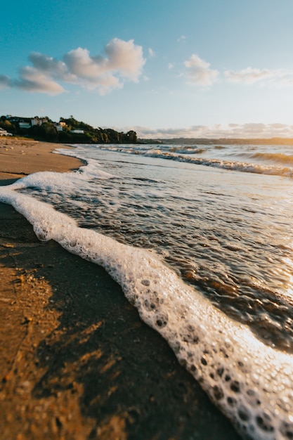 Super Nahaufnahme einiger Gezeiten mit Blasen am Strand während eines super bunten Sonnenscheins