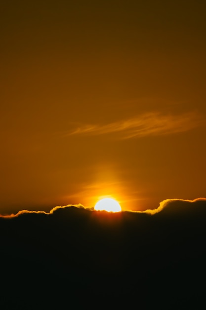 Súper puesta de sol sobre el fondo de pantalla de nubes negras en tonos cambiantes y tonos naranjas