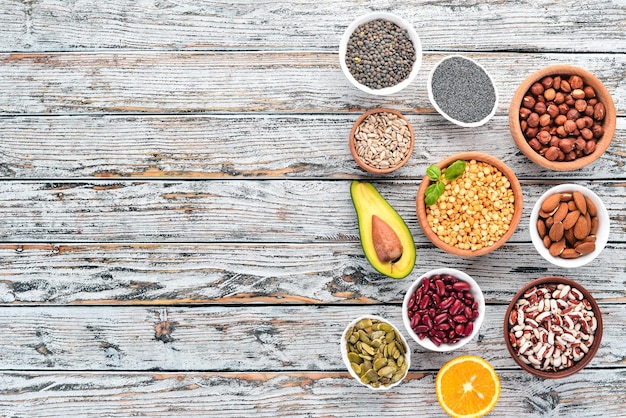 Foto superalimentos alimentos saludables nueces bayas frutas y legumbres sobre un fondo blanco de madera vista superior espacio de copia libre