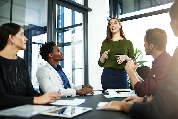 Superando além do esperado de sua foto de uma empresária fazendo uma apresentação para seus colegas de trabalho