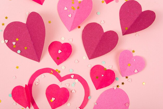 Superficie abstracta con corazones de papel, confeti para el día de San Valentín