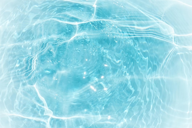 Una superficie de agua azul con un reflejo del sol sobre ella