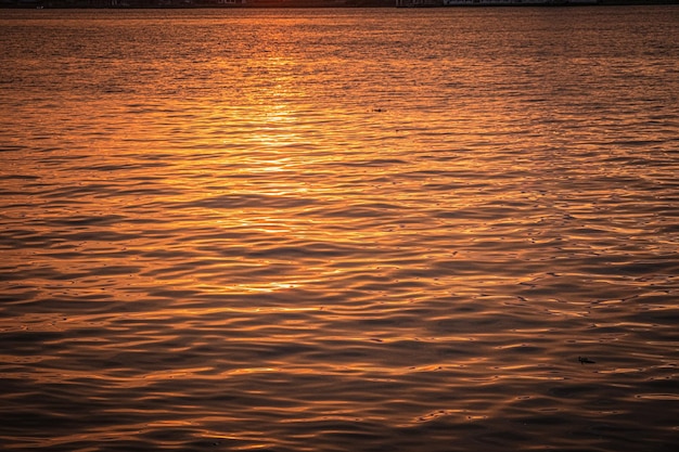 Superficie de agua ondulada al atardecer de la hora dorada