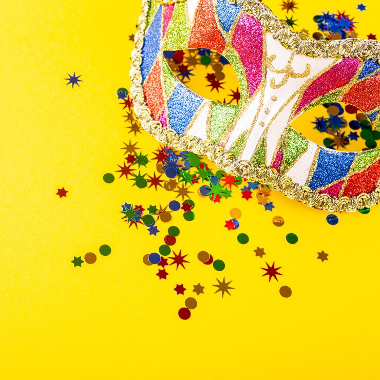 Superficie amarilla festiva con colorida máscara de carnaval. Concepto de tarjeta de felicitación para cumpleaños, carnaval, fiesta. Copie el espacio, vista superior, endecha plana