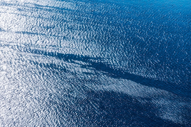 Superfície azul clara do mar com reflexo da luz solar,