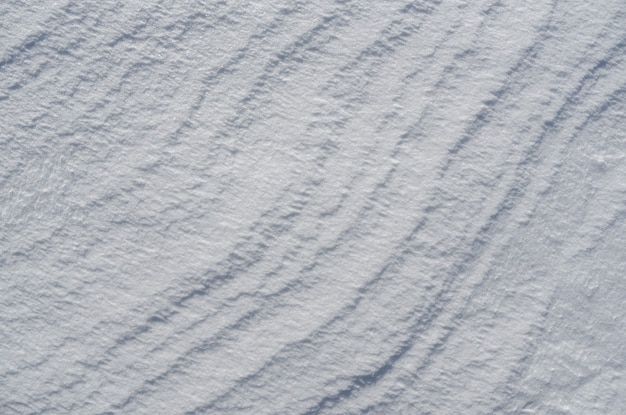 Superficie brillante de fondo cubierto de nieve con olas.