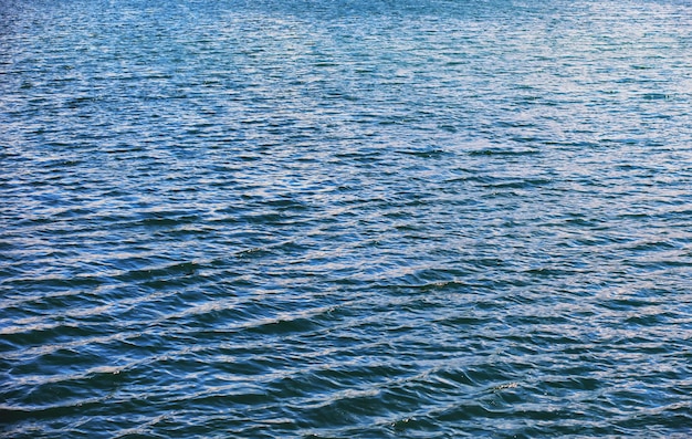 Superfície da água. A textura da água. Ondas no lago em tempo ventoso.